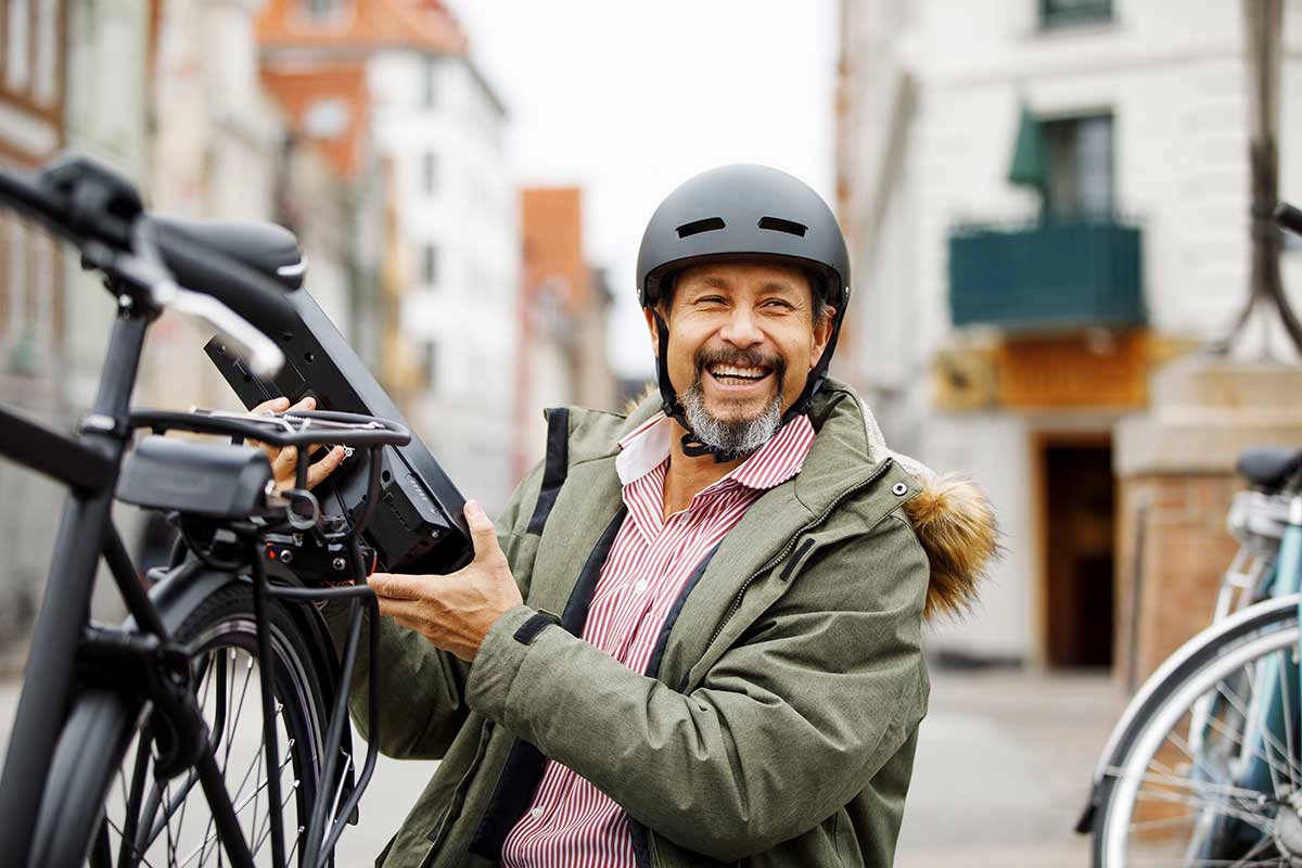 Ein lachender Mann neben seinem S-Pedelec